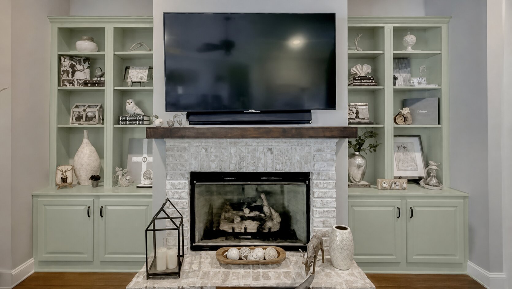 Paint Guru render — built-in bookcases and cabinets around the fireplace recolored to a light sage green