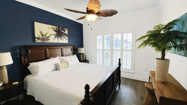 Paint Guru render — a deep navy accent wall behind the bed, the other walls and trim in bright white