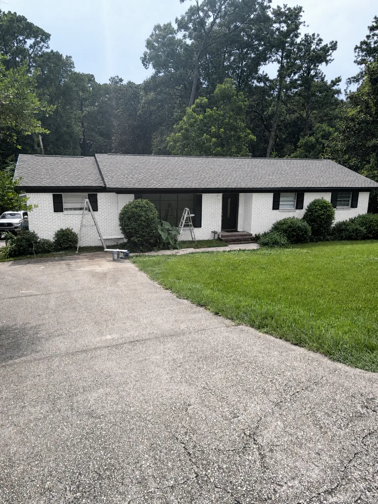Paint Guru render — brick ranch painted Pure White with Tricorn Black trim, shutters and front door