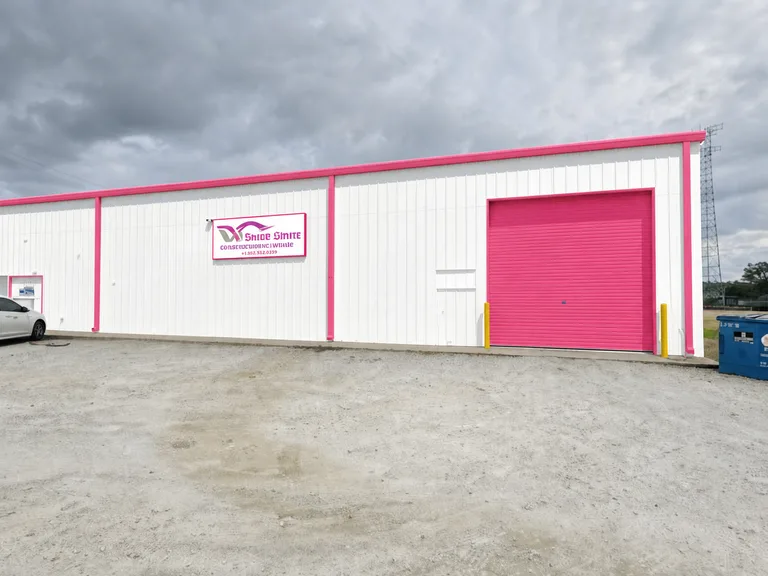 Paint Guru render — warehouse roll-up door and trim brand-matched to Redbud